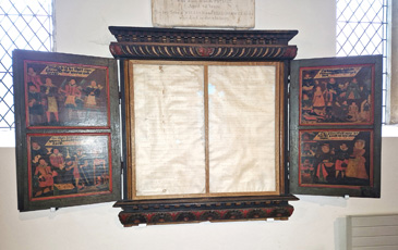 This large fixture in the parish church of Alcester, Warwickshire, is a very elaborate example of a benefaction board. These boards were set up in churches to record and memorialise key donors (benefactors) and acts of charity within the local community. They served as a public representation of bequests in wills and benefaction books recording the details of gifts to the parish. The Alcester benefaction board, dated 1632, is unusual in form and content  it is a triptych made up of a central panel, with two doors that open to reveal imagery on the interior sides. When closed, the exterior displays painted inscriptions. When open, there are four painted scenes showing charitable giving with relevant biblical texts either side of what would originally have been two parchments recording specific benefactions.<br />
<br />
While no records relating to this board survive, other churchwardens accounts suggest how benefaction boards were updated. For example, the 1641 accounts from St Mary Redcliffe, Bristol, record a payment to Morgan the painter for the new table (meaning board) and for writing in Mr Harringtons gift in the old. Such maintenance likely explains why the Alcester board was overpainted in the 1680s, when the parchments were probably updated.