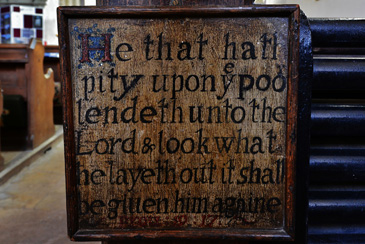 Almost every parish church in the 1600s had a poor box. This rare surviving example is from St Vincent Church in Claythorpe, Lincolnshire and is currently positioned at the top of the nave. It displays a Biblical inscription from proverbs 19:17, which reminds the viewer of the importance of giving and charity for their own salvation.<br />
<br />
The text is inscribed into the oak using mastic, a common method of decorating wood cheaply without the need for skilful carving. It has a lock at the top to keep donations secure. Churchwardens, who were often middling tradesmen, controlled funds from the poor box. The vestry minutes of St Thomas Church, Salisbury, in 1637, record the churchwardens working with the overseers of the poor in order to provide for the sicke and necessitous poore of this parish from the boxs funds.<br />
<br />
This object serviced the practice of short term, small donations to a parish and represents the authority middling officeholders held over the distribution of poor relief at a local level.