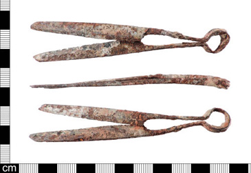 These iron shears were found in Southwark, London, and consist of two blades joined by a loop. Shears and scissors were common tools in medieval and early modern England, useful for a variety of work, some of which we would think of as commercial and some more domestic. For early modern households where the two were often taking place within the same spaces, however, tools like these shears could make the connection between types of activity. They had a variety of uses depending on their size, with larger shears playing an important role in the textile industry. Some were used in sheep shearing, while others were used by tailors to cut cloth. Shears and pressing irons were the tailors main tools, although they did also need proximity to a fire to warm the irons. <br />
<br />
Many people of middling status were involved in the textile industry, from the merchants trading wool to the shearmen, tanners, glovers and tailors who relied on these natural materials for their craft. Shears were often used as symbols of the textile trades, for example on tokens issued by cloth merchants and tailors in the seventeenth century (see e.g. PAS <a href='https://finds.org.uk/database/artefacts/record/id/1023152' target='_blank'>HESH-122311</a>). Although most tools were individually owned  part of the working capital of each craftsman rather than belonging to a workshop more generally  when William Byston, a shearman, died in Southampton in 1558, his possessions included 9 pairs of working shears and a grindstone. He left his sons John and Richard all the implements in my 2 shops equally divided including the shears.<br />
<br />
The shears selected for this exhibition are small, however, measuring 10.5 cm in length and 2.1 cm in width. Their size suggests that they were used for household work, perhaps for needlework or in the kitchen. They are operated by pressing the two sides together below the meeting point, making a close relationship between the hands of the user and the material being cut. Shears were essential tools of middling domestic and professional life as, unlike the gentry, the middling sort relied on an occupation for their wealth and status. 