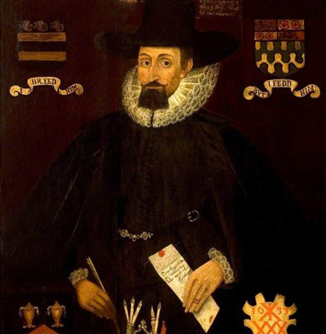 This painted portrait of Salisbury merchant William Windover was made following his death to record and celebrate his gift of fifty pounds as a legacy to the Company of Shoemakers, as recorded in the inscription which also hopes his soul will rest with God forever. It is a memorial and a record of benefaction similar to those included elsewhere in this exhibition. But this portrait also establishes Windovers reputation for posterity through a range of visual symbols. These symbols speak to the various routes to social and financial credit that many successful middling men used to build their status. <br />
<br />
The portrait includes a combination of pseudo-armorials, heraldic badges that reveal his biography as a citizen and professional. At top left is the arms of New Sarum (Salisbury), with the words I Breed Him. At top right is the arms of the Merchant Adventurers' Company of London and the words 'But I Fedd Him', and in the bottom left the arms of the Drapers' Company with 'I Made Him Free'. This suggests Windovers successful career through professional guilds. In the bottom right is a shield bearing Windover's merchant's mark with the date 1633, likely the year of his death, and the words 'Yet Knowne by Me' (remembered by both the men listed within the inscription as witnesses to his gift and, presumably, by the viewer looking on his image).<br />
<br />
There are other signs in this posthumous portrait that construct his reputation as a highly literate man of business; he is holding a letter while dipping a quill into the fancy inkstand prominent in the foreground, which also holds a seal and wax. The black clothing may indicate a strict form of Protestant piety, but it also exhibits his wealth (note the impression of velvet in the cloak and the fine quality of ruff and cuffs.   